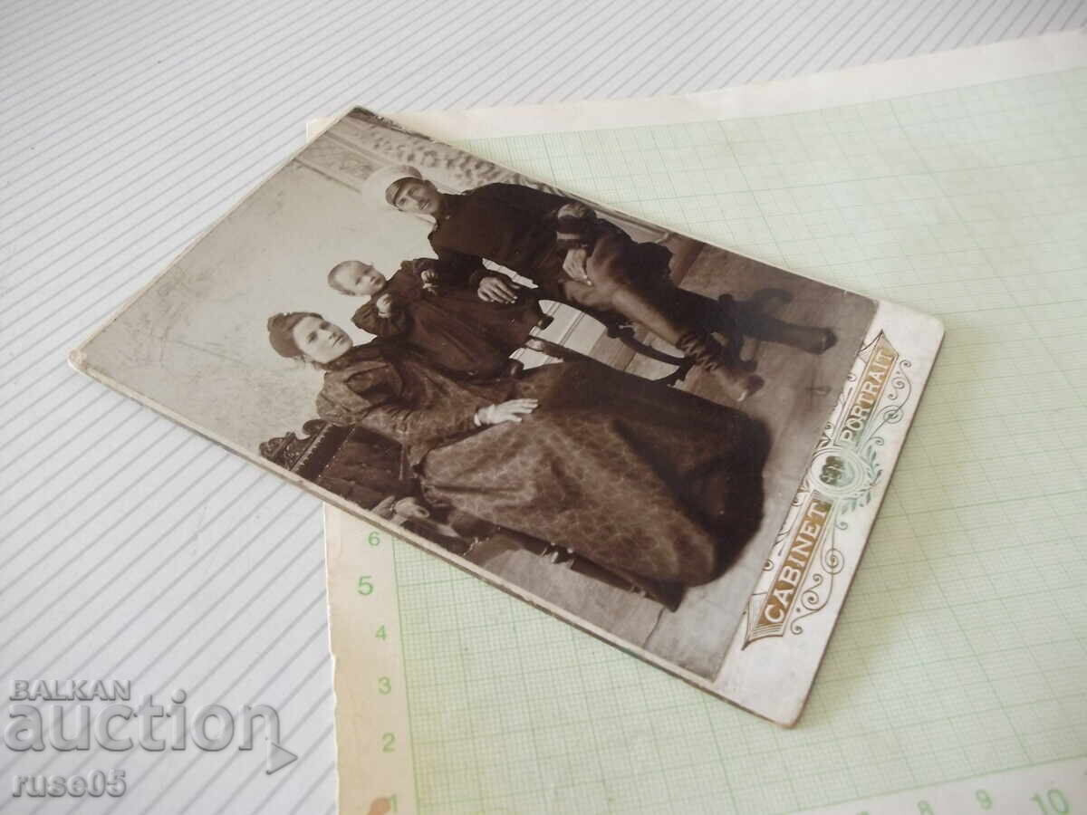 Licitație Fotografie veche pe carton cu un militar și familia sa într-un studio foto
