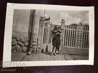 Girl with a bouquet on the doorstep of a house 1945