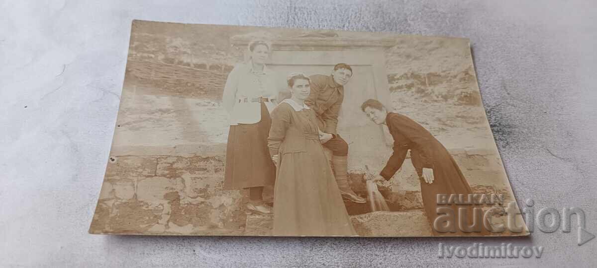Photo: A young man and three young women at the fountain