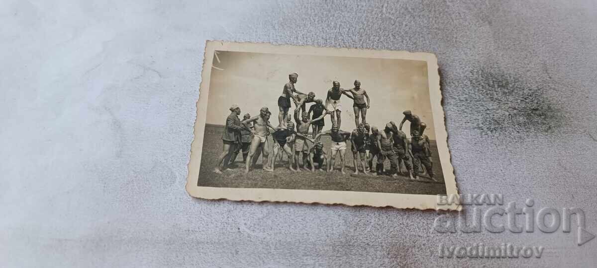 Fotografie soldați în pantaloni scurți făcând o piramidă Fotografie soldați în pantaloni scurți făcând o piramidă