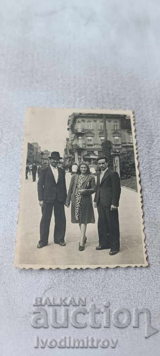 Fotografie Sofia Doi bărbați și o fată tânără pe trotuar Fotografie Sofia Doi bărbați și o fată tânără pe trotuar