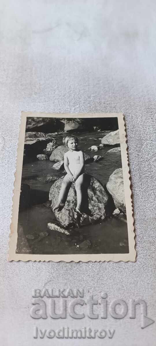 Photo Little girl on a rock in the river