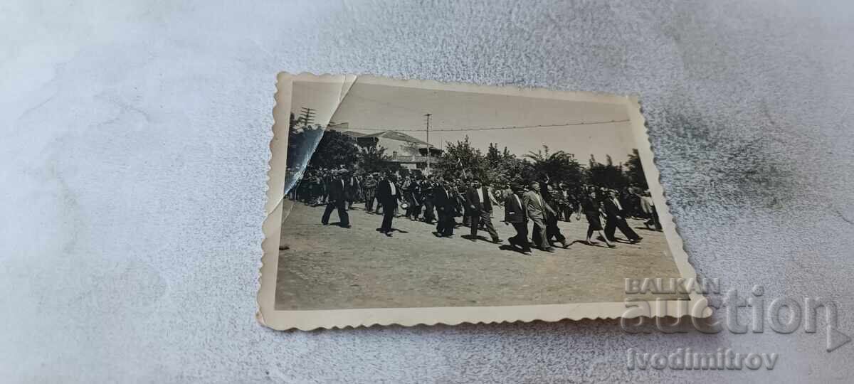 Photograph of men and women at a street procession