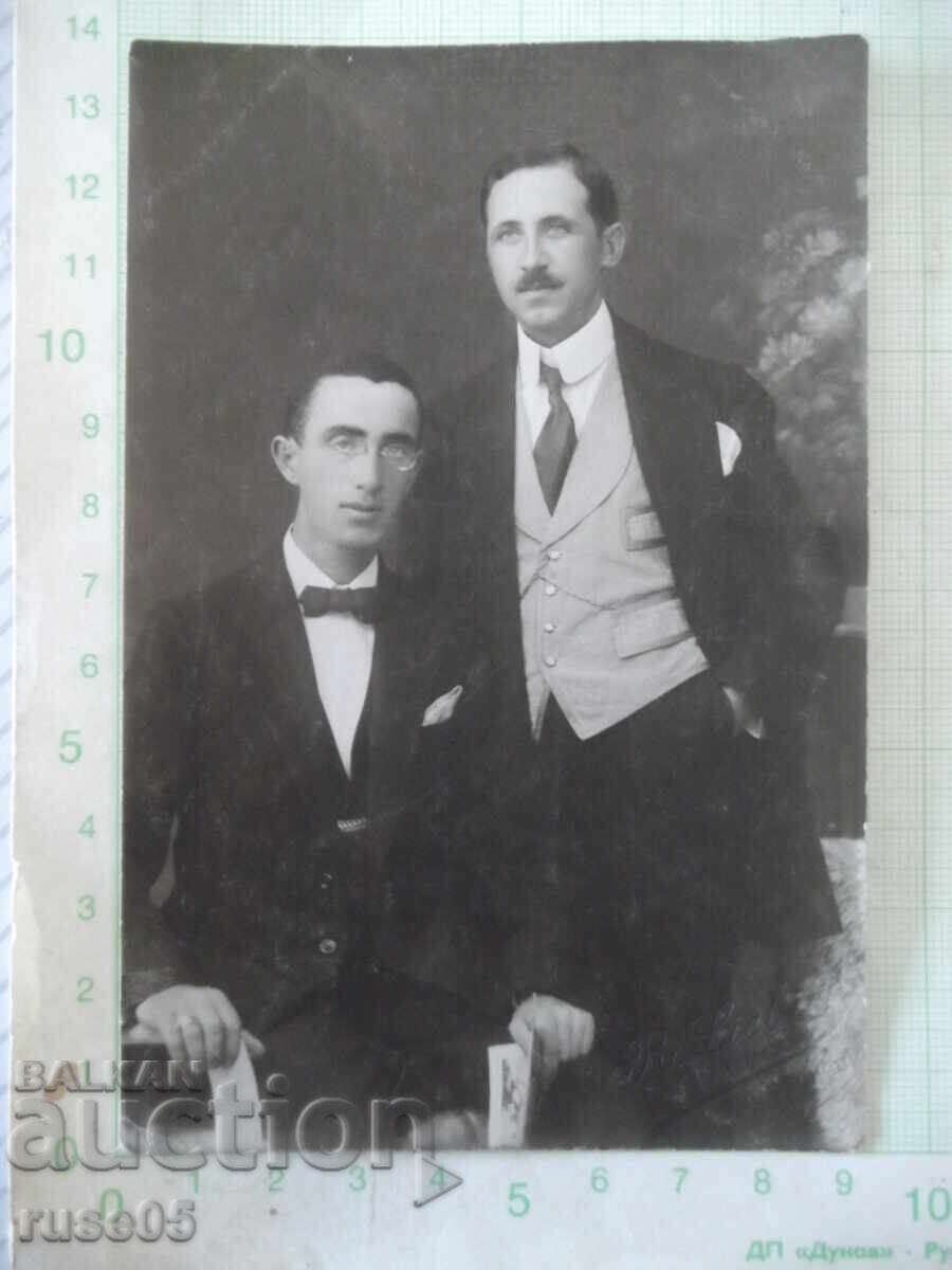 Fotografie veche cu doi domni într-un studio foto