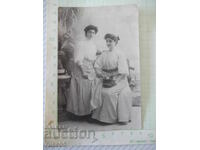 Fotografie veche cu două domnișoare într-un studio foto