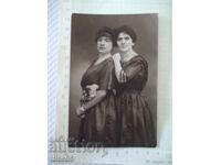 Fotografie veche cu două domnișoare în negru într-un studio foto