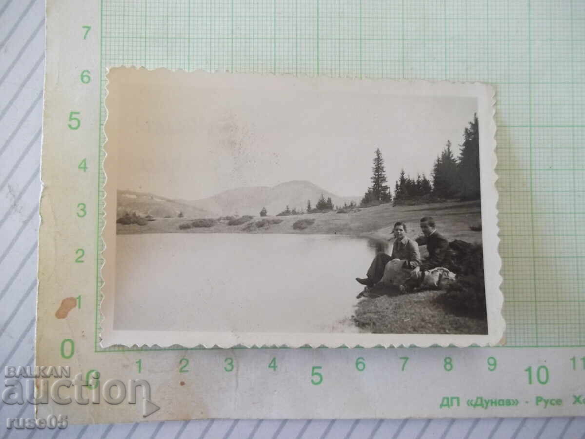 Fotografie veche cu doi tineri pe malul unui lac din Rodopi