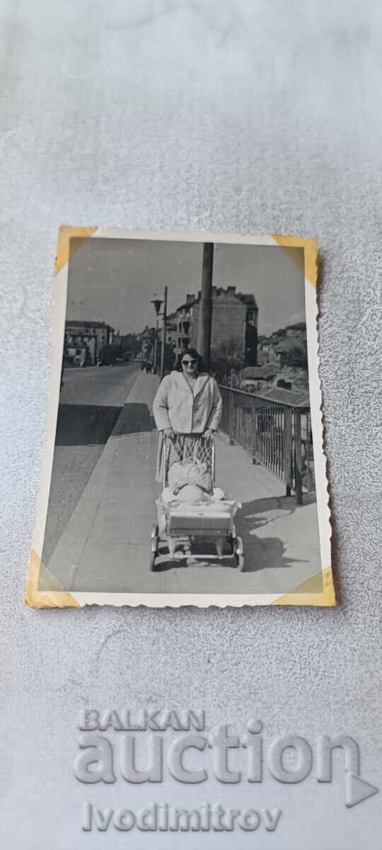 Photo Sofia A woman with a retro baby carriage for a walk