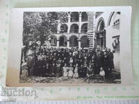 Fotografie veche cu un grup de credincioși într-o mănăstire cu preoți
