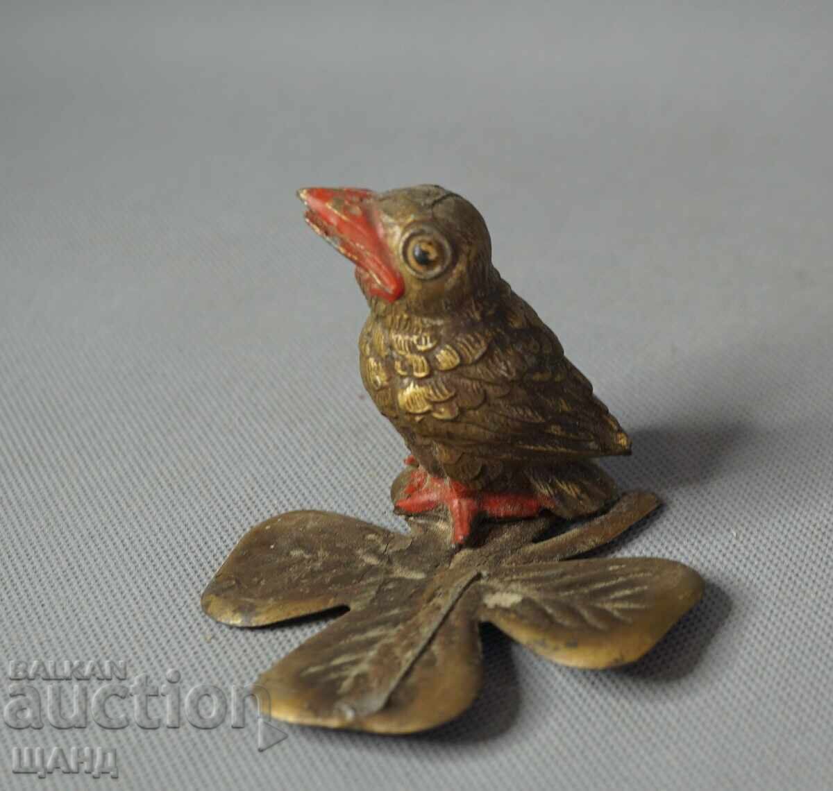 Vintage metal bird figurine on a leaf