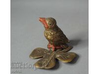 Vintage metal bird figurine on a leaf