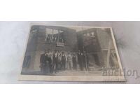 Photograph of men and boys in front of a house under construction