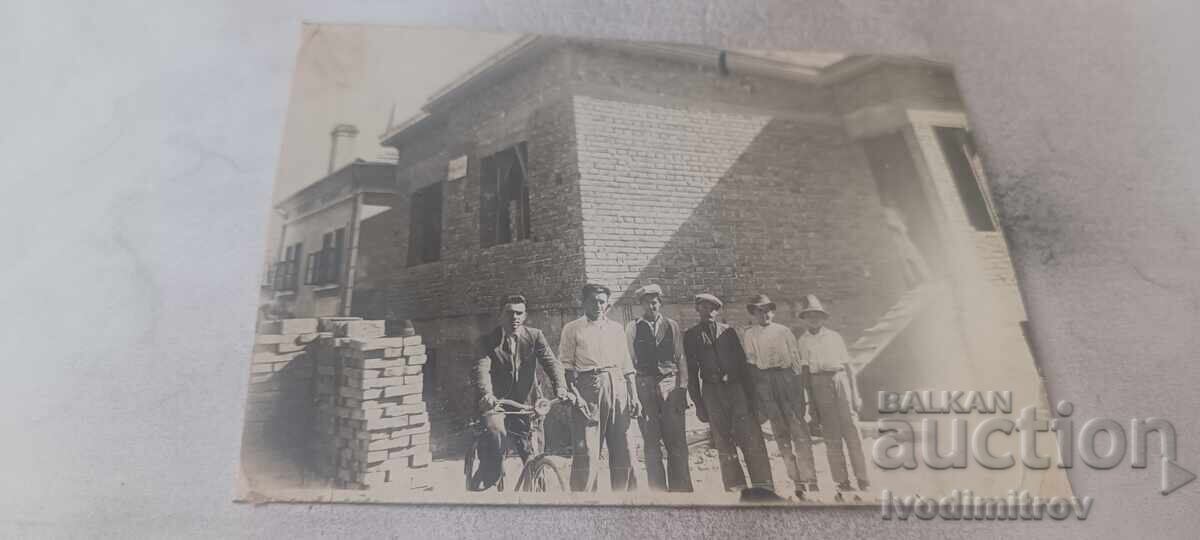 Photo Men in front of a newly built house